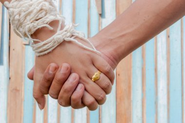 Gelin ve damat renk ahşap arka plan ile ellerini tutun