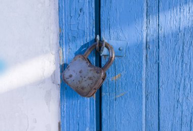 Kapıda eski bir kilit asılı.