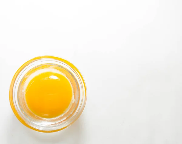Minimalism, an egg in a pot, on a white background. The testicle is in the lower left corner. top view