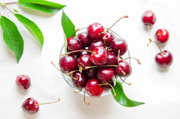 Cherries in the center of the frame, on a light background.