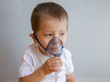 Çocuk nebulizörle nefes alıyor. Çocuğa öksürük tedavisi yapılır..