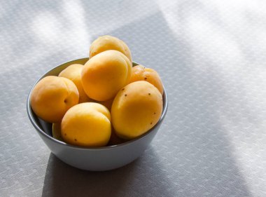 Apricots in a cup on the table.