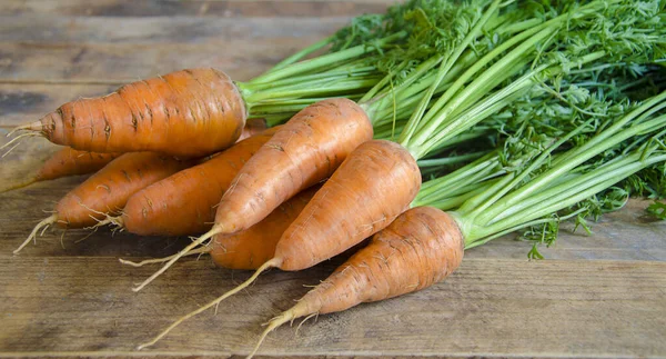 A bunch of carrots on a wooden table. — Stock Photo, Image