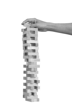 Jenga beyaz arka plan üzerinde oynayan siyah ve beyaz el