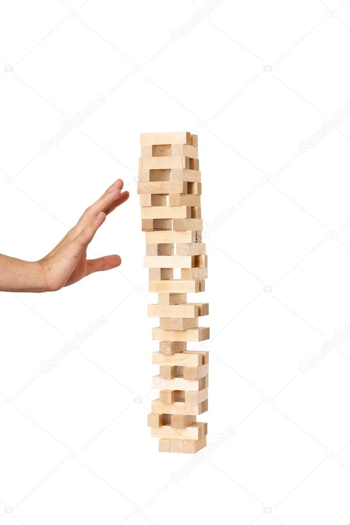 Hand playing in jenga on white background