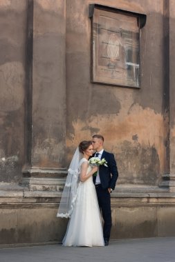 Güzel bir eski duvara yakın duran genç Düğün çifti 