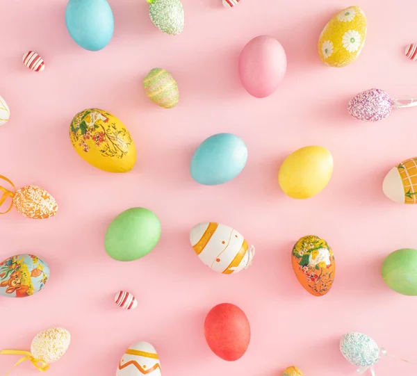 Değişik malzemelerden, renklerden ve boyutlardan oluşan renkli Paskalya yumurtaları. Pastel pembe arka planda düz konsept.