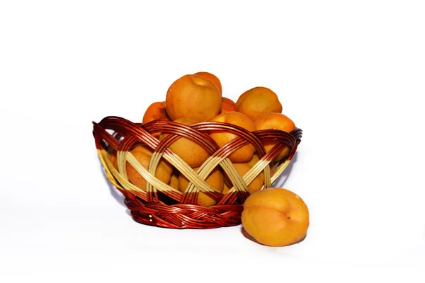Apricots in wicker basket on white background — Stock Photo, Image