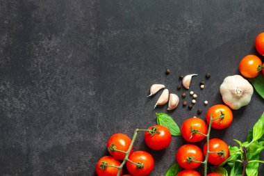 Üzüm domatesleri, sarımsak karanfilleri ve karabiber ile pişirmek için kullanılan çeşitli baharatların olduğu düz masa veya üst masa..