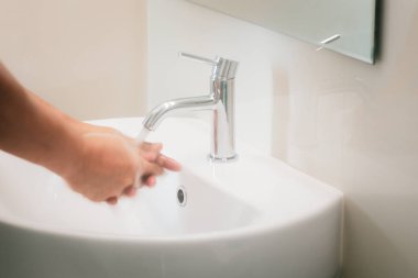 El yıkama, korunma, koronavirüs ya da Covid19 konsepti dışında ellerini yıkama ya da temizleme ile musluktan su yakalamak için ellerinizi birleştirin..