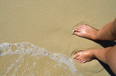 Dalgalar deniz ve kız ayakları üzerinde yaz kum plaj. Üstten Görünüm