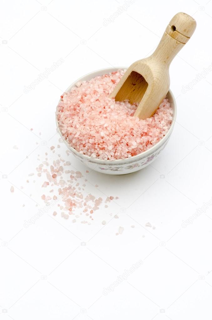 wooden scoop, bowl full of bath salts with pink and white grains