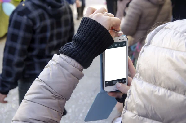 Eller insanlar arasında smartphone ve beyaz ekran ile fotoğraf çekimi