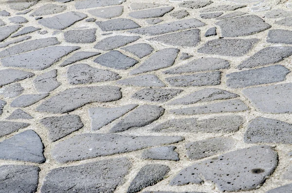 Piso de la antigua piedra adoquinada con rocas de varios tamaños y — Foto de Stock