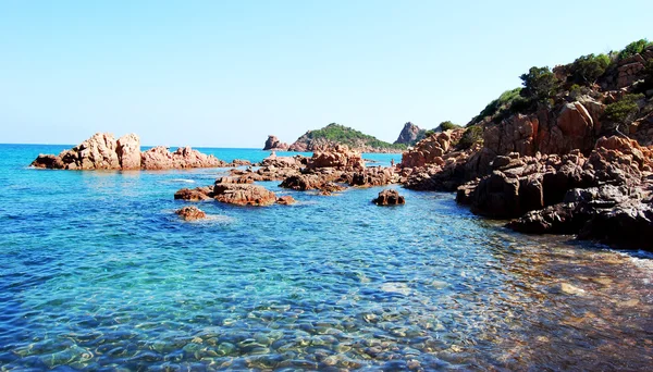 Paisagem do mar em dia ensolarado com pedras vermelhas espalhadas e claras w — Fotografia de Stock