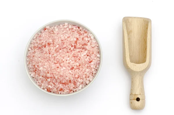 Cuillère en bois, bol rempli de sels de bain avec des grains roses et blancs — Photo