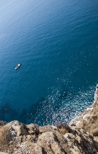 Ovansida av en djupblå havet och klipporna vid kusten. En liten boa — Stockfoto