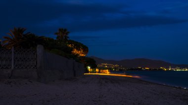 Yapay ışık altında sahilde hareket neredeyse gece sahilde bazı insanlar huzurlu ve gün batımı