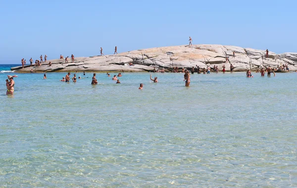 Gente no identificada en la playa llamada Scoglio di Peppino. Día soleado en verano, agua cristalina como una piscina natural — Foto de Stock