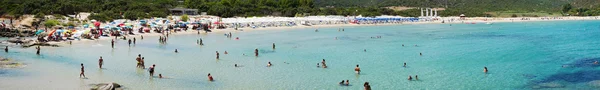 Неизвестные люди на пляже под названием Scoglio di Peppino. Панорамный вид, солнечный день в летнее время, хрустальная вода, как природные какашки — стоковое фото