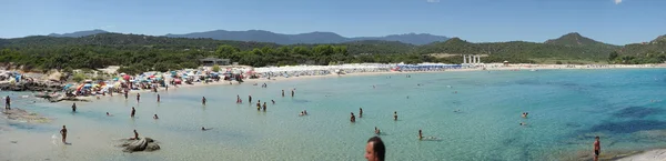 Неизвестные люди на пляже под названием Scoglio di Peppino. Панорамный вид, солнечный день в летнее время, хрустальная вода, как природные какашки — стоковое фото