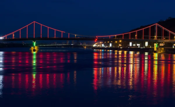 Luces de noche de la ciudad y puente con reflejos sobre el río — Foto de Stock