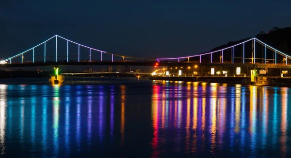 Luci notturne città e ponte con riflessi sul fiume — Foto Stock