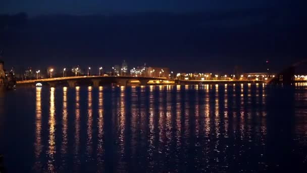 Luzes de cidade noturna e ponte com reflexões sobre o rio — Vídeo de Stock