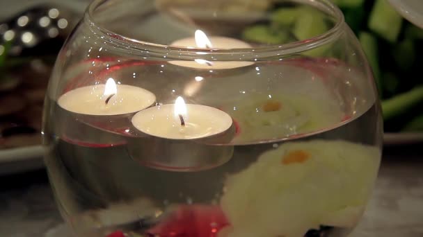 Burning candles floating in a decorative vase — Stock Video