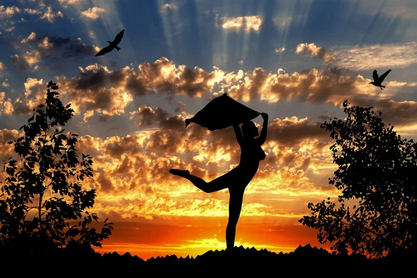 Молода дівчина силует з хусткою танцює на золотому хмарному фоні заходу сонця — стокове фото