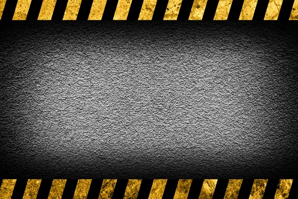 Grunge-grauer Wandhintergrund mit schwarz-gelben Warnstreifen — Stockfoto
