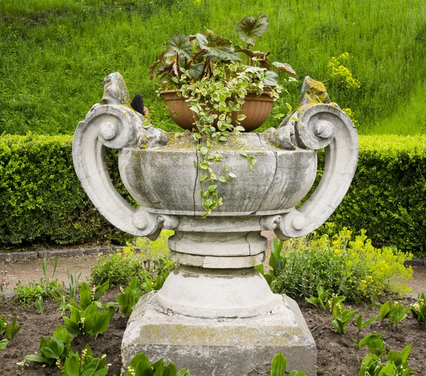 Stone vase with flowers in the garden Stock Picture