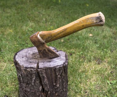 Bahçedeki ahşap Ahşap içine yeşil çim arka plan üzerinde tahrik balta