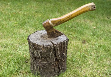 Bahçedeki ahşap Ahşap içine yeşil çim arka plan üzerinde tahrik balta