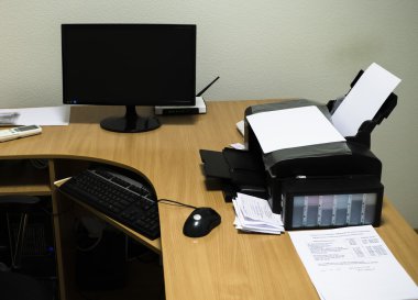 Çalışma alanı ahşap masa, bilgisayar, yazıcı, monitör, fare ve klavye ile