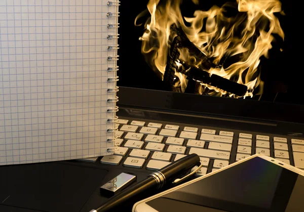 Lieu de travail de bureau avec ordinateur portable, téléphone intelligent, stylo, lecteur flash et wordpad avec fond de feu brûlant — Photo
