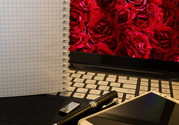 Lieu de travail de bureau avec ordinateur portable, téléphone intelligent, stylo, lecteur flash et wordpad avec fond rose — Photo