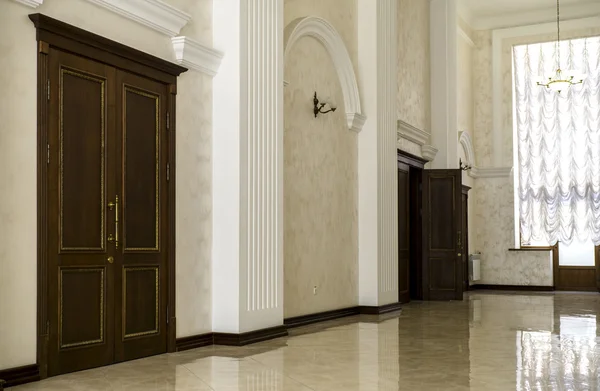 Corridoio bianco con pavimento in marmo, porte marroni e finestra in ospedale — Foto Stock