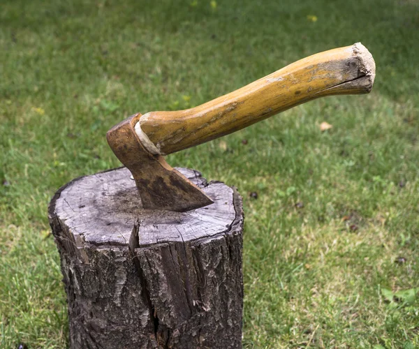 Bahçedeki ahşap Ahşap içine yeşil çim arka plan üzerinde tahrik balta