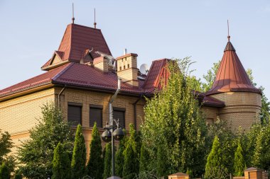 Kiev, Ukrayna - 15 Temmuz 2015: Turuncu modern kır evi kırmızı çatılı, mavi gökyüzü arka plan üzerinde ağaç bahçe