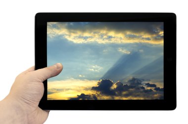Tablet PC el altın günbatımı arka plan üzerinde beyaz izole ekran ile güzel mavi gökyüzü ile