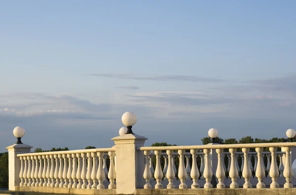 Valla decorativa de columnas en el paseo marítimo sobre fondo de cielo azul y nubes — Foto de Stock