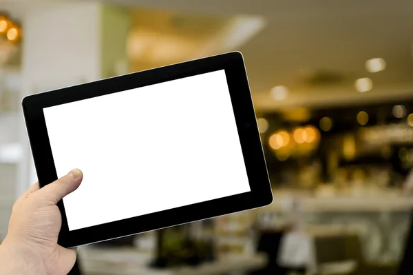 Leerer Tablet-PC in der Hand im Café-Bar-Interieur mit Lampen — Stockfoto