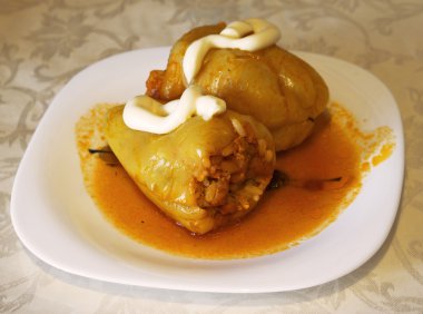 Yeşil çan et, pilav ve filtre beyaz plaka üzerinde kırmızı soslu mantar dolması