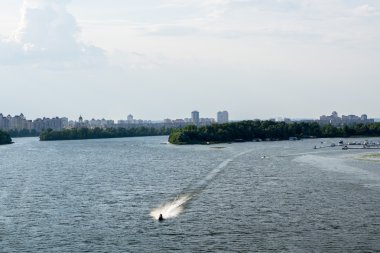 Tekne, orman, çalılar, evler ve gökyüzü ile Nehri Panoraması