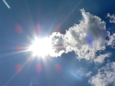 Bulutlu mavi gökyüzü ve parlak güneş bir kuyruklu yıldız gibi