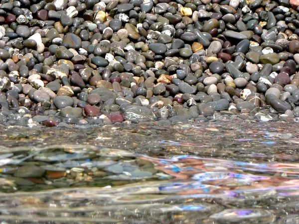 Stones on background of sea water with reflections — Stock Photo, Image