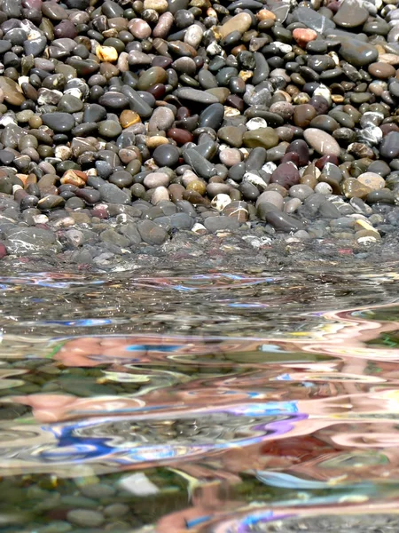 Pedras no fundo da água do mar com reflexos — Fotografia de Stock