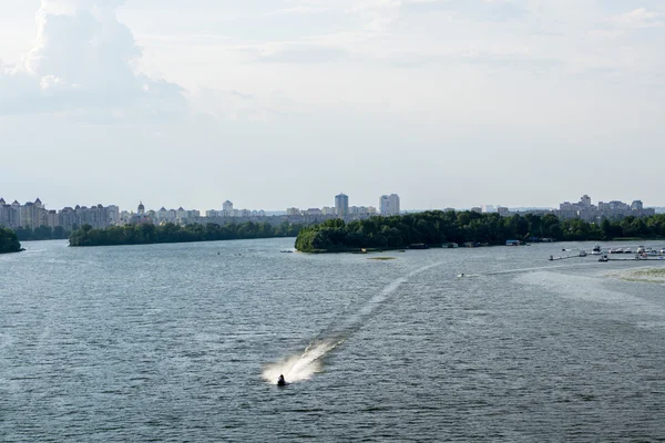 Tekne, orman, çalılar, evler ve gökyüzü ile Nehri Panoraması