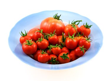 Büyük mavi plaka üzerinde beyaz izole kırmızı domates ile